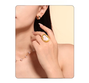 Detail of baroque pearl ring and colorful gemstone hoop earrings on female model