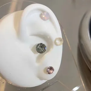Titanium steel screw-back earrings with colorful round cubic zirconia on ear model