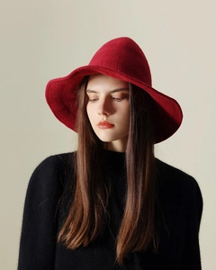 Close-up of deep red knitted wool wizard hat featuring a wide brim and textured finish