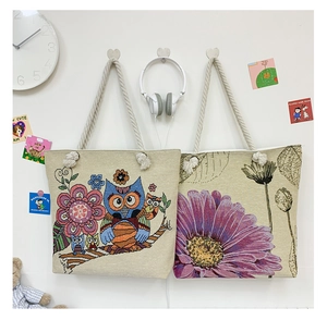 Detail view of double-sided jacquard canvas tote bags with owl and floral embroidery