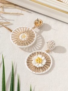 Detail of bohemian raffle flower earrings with white woven rope and pearl studs