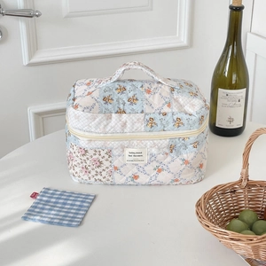 Quilted floral makeup bag with light blue patchwork patterns and portable handle