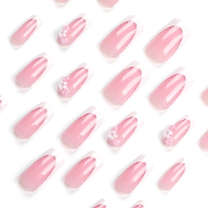 Pink gradient long press-on nails with glitter and 3D floral accents in flat lay style
