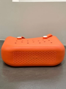 Detail of waterproof orange EVA beach tote showing side holes and non-slip bottom texture