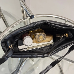 Quilted black bucket bag with interior view showing capacity for phone and cosmetics