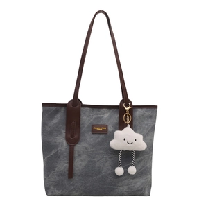 Large gray canvas tote bag with brown leather trim and a cute cloud plush charm