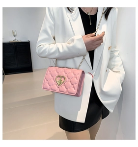 Détail du sac bandoulière matelassé rose avec fermoir cœur en métal et chaîne