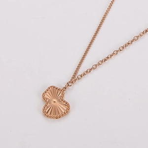 Macro detail of rose gold gourd pendant with radial texture and beaded edge