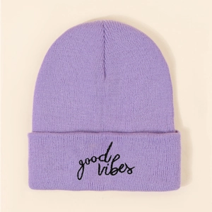 Detail of light purple knitted beanie with black good vibes embroidery on front fold