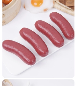 Macro detail of four realistic artificial sausages on a white rectangular ceramic plate