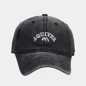 Detailed macro of white 3D AQUIVER embroidery on washed black vintage baseball cap