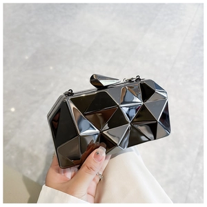 Detail of black geometric diamond cut evening clutch with glossy mirror finish