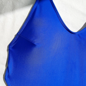 Macro detail of royal blue swimsuit fabric showing high elasticity and fine stitching