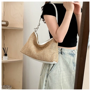 Detail of hand-woven straw tote bag with white leather trim and knotted shoulder strap