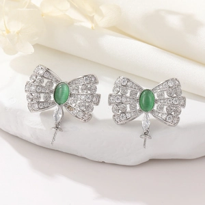 Detail of silver bow earrings with green cat eye stone and pavé cubic zirconia accents