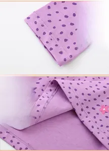 Detailed view of purple polka dot dress with sleeve cuffs and floral hem embroidery