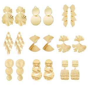 Detail view of 9 pairs golden geometric earrings with hammered texture and leaf shapes