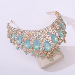 Close-up of golden crown featuring light blue teardrop stones and clear rhinestones