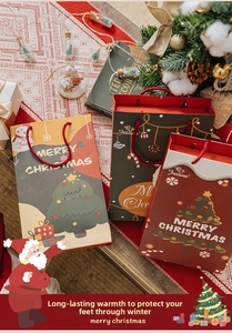 Detailed view of festive Christmas gift bags with Santa and tree motifs and red handles
