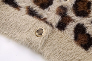 Makro-Detail des Plüsch-Cardigans mit Leopardenmuster und goldumrandetem Harzknopf