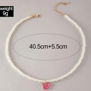 Macro shot of pink butterfly pendant pearl necklace with lobster clasp and chain