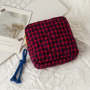 Quilted red and black plaid cosmetic bag with yellow zipper and blue cord knot