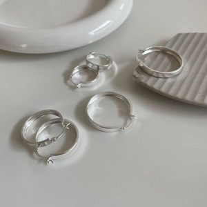 Macro view of minimalist S925 sterling silver hoop earrings in various sizes and silver finish