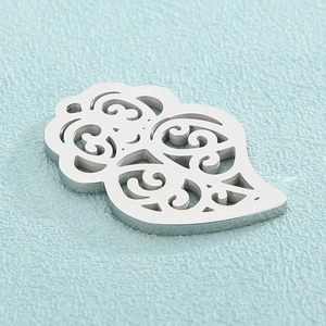 Detailed close-up of hollow leaf-shaped stainless steel pendant with vintage filigree patterns