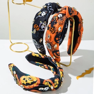 Close-up of Halloween headbands featuring pumpkin prints and sparkling rhinestone details