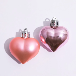 Pink heart-shaped Christmas ornaments in matte and glossy finishes on white background