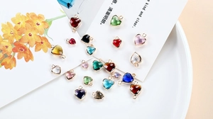 Macro shot of colorful crystal heart pendants with gold plated copper edges for DIY jewelry