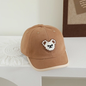 Close-up of children baseball cap featuring a cute bear patch and canvas texture