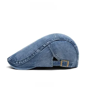Side view of blue denim flat cap with adjustable gold metal buckle and stitching