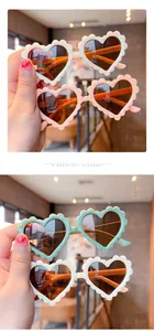Detail of colorful heart shaped sunglasses for kids with unique wavy frames and dark lenses