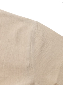 Detail of shoulder seam on beige linen cotton henley shirt with breathable weave texture
