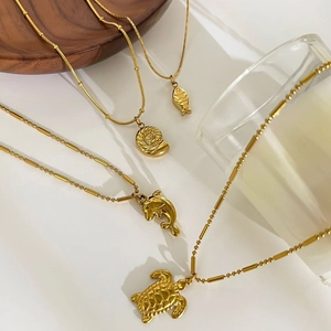 Golden ocean jewelry set featuring sea turtle, dolphin and seashell pendant necklaces