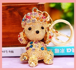 Close-up of golden poodle keychain with sparkling colorful rhinestones on a desk