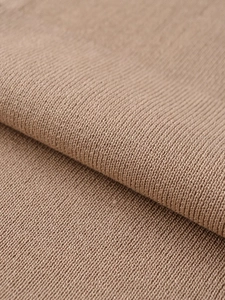 Close-up of camel knit fabric showing high-density texture and soft wool blend material