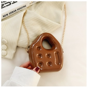 Detailed view of a brown PVC mini jelly bag with golden chain strap and hole design