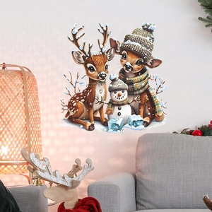 Christmas reindeer and snowman window stickers applied on a wall near a warm lamp
