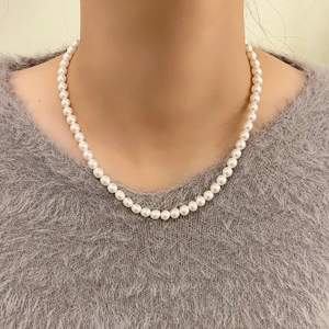Close-up of 2mm white crystal pearl necklace on model neck with grey sweater
