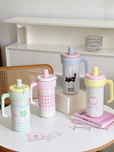 Close-up of insulated coffee tumblers in four pastel colors with cute cartoon patterns