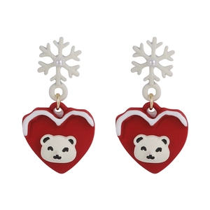 Detail of Christmas earrings featuring red heart charms with polar bear and snowflake accents