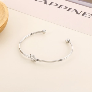 Détail du bracelet ouvert en acier inoxydable argenté avec nœud et perles fines