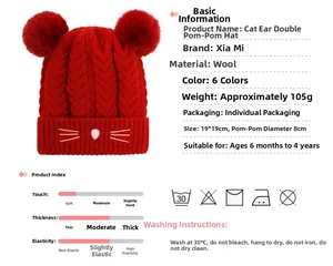 Detail of red cable-knit baby hat with cat face embroidery and two large pompoms