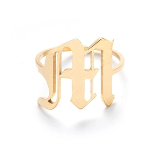 Detailed close-up of a vintage gold-plated gothic letter M ring with intricate patterns