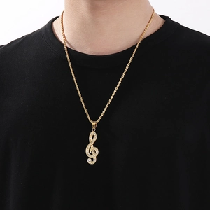 Detailed view of hip hop music note pendant with gold plated stones on twisted chain