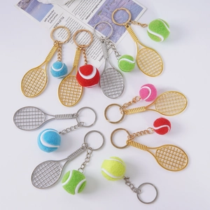 Gros plan de porte-clés raquettes de tennis avec balles en peluche et finitions métalliques