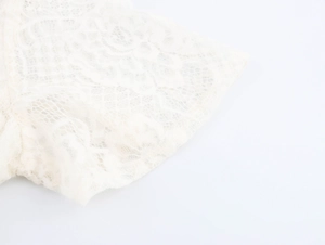 Close-up of elegant white floral lace fabric with intricate mesh patterns and textures