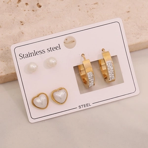 Three pairs of stainless steel earrings with hearts, pearls and crystals on card